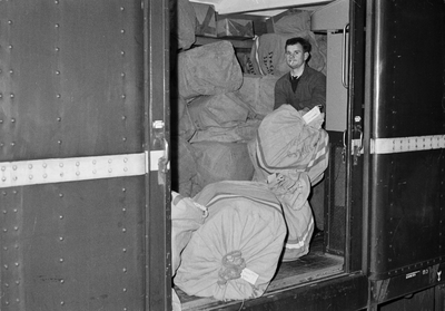 128931 Afbeelding van het beladen van een posttrein tijdens de Sinterklaasdrukte bij de pakketpost op het Centraal ...